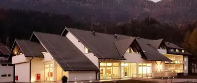 a large white house with a black roof at klass 203 in Kranjska Gora