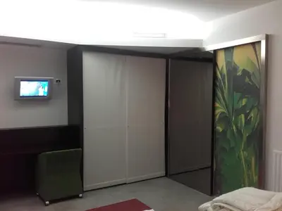 a bedroom with white closets and a tv on the wall at klass 203 in Kranjska Gora
