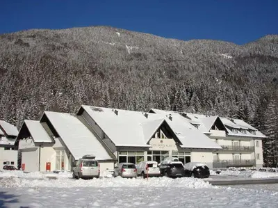 a building with cars parked outside of it in the snow at klass 203 in Kranjska Gora