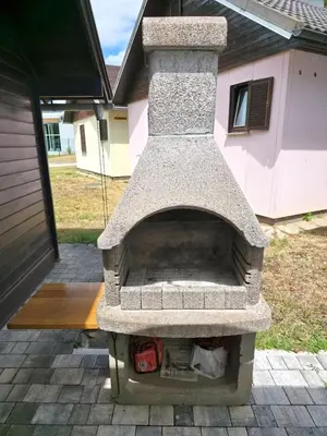 a stone oven sitting outside of a house at Cozy Cabin in Čatež ob Savi
