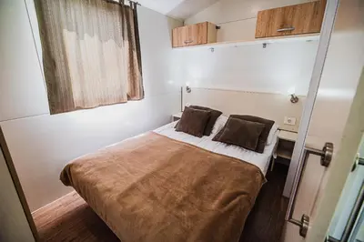 a small bedroom with a bed with two pillows at Lake View Mobile Homes with Thermal Riviera Tickets in Terme Čatež in Čatež ob Savi