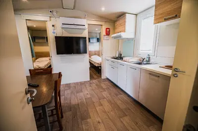 a small kitchen with white cabinets and a sink at Lake View Mobile Homes with Thermal Riviera Tickets in Terme Čatež in Čatež ob Savi