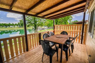 a wooden deck with a table and chairs on it at Lake View Mobile Homes with Thermal Riviera Tickets in Terme Čatež in Čatež ob Savi