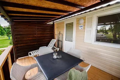 a patio with a table and chairs on a deck at Lake View Mobile Homes with Thermal Riviera Tickets in Terme Čatež in Čatež ob Savi