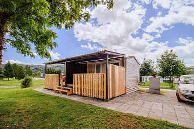 a small cabin with a car parked in a yard at Lake View Mobile Homes with Thermal Riviera Tickets in Terme Čatež in Čatež ob Savi