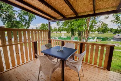 a patio with a table and chairs on a deck at Lake View Mobile Homes with Thermal Riviera Tickets in Terme Čatež in Čatež ob Savi