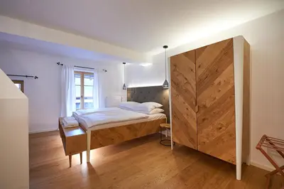 a bedroom with a bed and a large wooden cabinet at Hotel Plesnik Logar Valley in Solčava