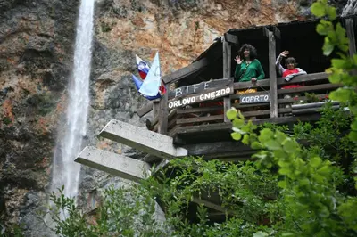 a group of people looking out of a window at a waterfall at Hotel Plesnik Logar Valley in Solčava