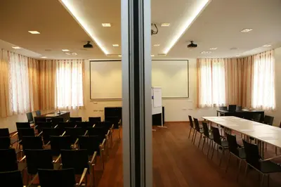 a conference room with tables and chairs in it at Hotel Plesnik Logar Valley in Solčava