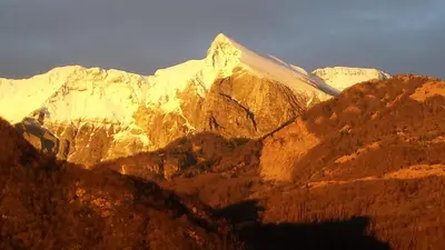 a view of a mountain range with the sun shining on it at Apartment Green Valley in Idrsko