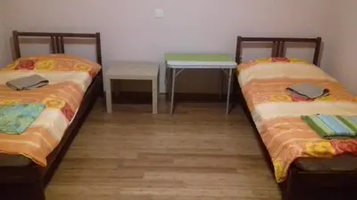 two beds in a room with a table and a desk at Apartment Green Valley in Idrsko