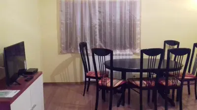 a dining room with a table and chairs and a window at Apartment Green Valley in Idrsko
