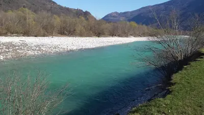 a river with green water and mountains in the background at Apartment Green Valley in Idrsko