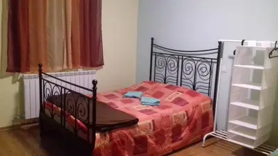a bedroom with a black bed with a red blanket at Apartment Green Valley in Idrsko
