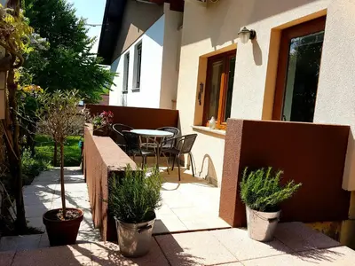 a patio with a table and chairs and plants at Sky in Bled