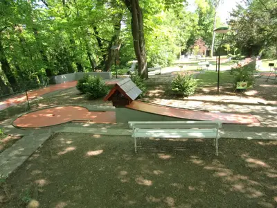 a park with a bench and a skate ramp at Sky in Bled