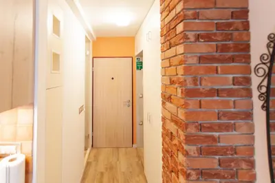 a brick wall in a hallway with a door at Chic Cosy Quiet in Ljubljana Center in Ljubljana
