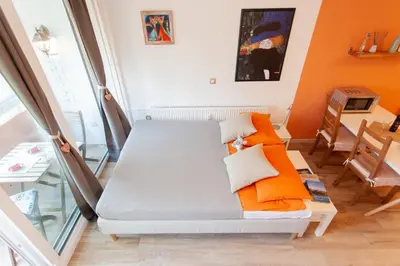 a room with a bed with orange and white pillows at Chic Cosy Quiet in Ljubljana Center in Ljubljana