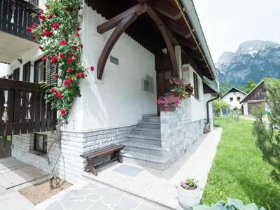 a building with a bench on the side of it at Apartments and rooms Nataša 2 in Trenta