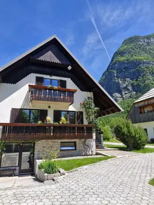 a house in the mountains with a balcony at Apartments and rooms Nataša 2 in Trenta