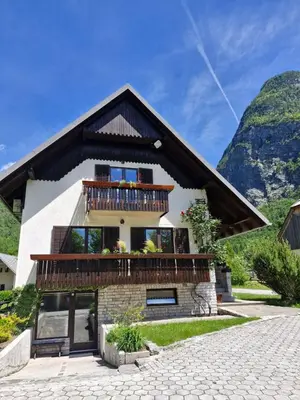 a house in the mountains with a balcony at Apartments and rooms Nataša 2 in Trenta