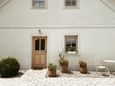 a white house with a door and a table and chairs at Tri lučke Hotel & Restaurant in Krško