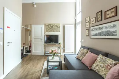 a living room with a blue couch and a tv at Rohrmann apartments in Ljubljana