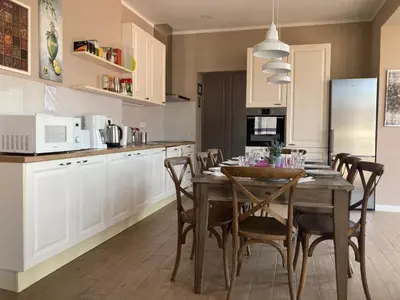 a kitchen with a wooden table and chairs in a kitchen at Rohrmann apartments in Ljubljana