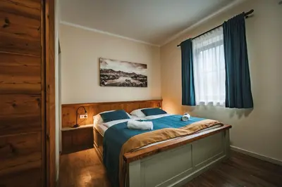 a bedroom with a bed with blue sheets and a window at Guest House EJGA in Jesenice