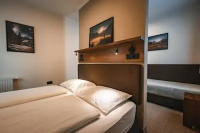 a hotel room with a bed with a head board at Guest House EJGA in Jesenice