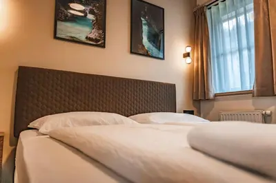 a bedroom with two beds and two pictures on the wall at Guest House EJGA in Jesenice