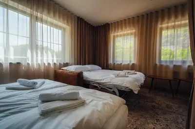 two beds in a room with two windows at Guest House EJGA in Jesenice