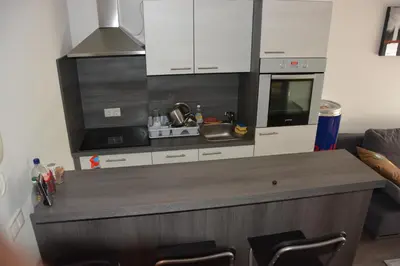 a kitchen with white cabinets and a counter top at Apartment Velcom in Moravske Toplice