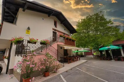 a building with flowers on the balconies and tables at Domačija Bubec in Ilirska Bistrica
