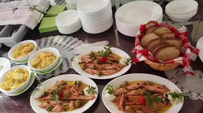 a table with plates and bowls of food and bread at Domačija Bubec in Ilirska Bistrica