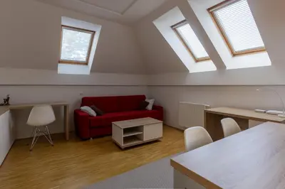 a living room with a red couch and two windows at Bled4U Apartment in Bled