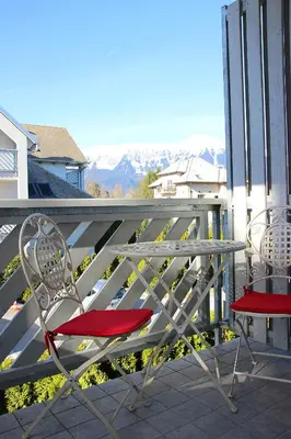 two chairs and a table on a balcony with mountains at Bled4U Apartment in Bled