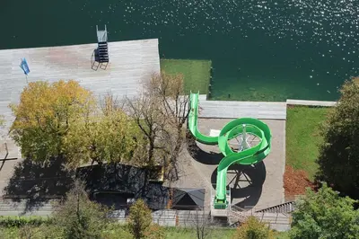 a green sculpture on the side of a building next to the water at Bled4U Apartment in Bled