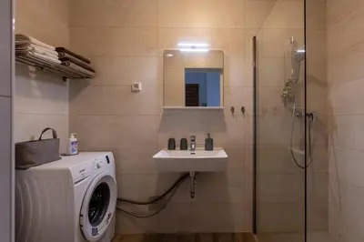 a bathroom with a washing machine and a sink at Bled4U Apartment in Bled