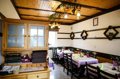 a restaurant with tables and chairs in a room at Guest House Vila Moj Mir in Rateče