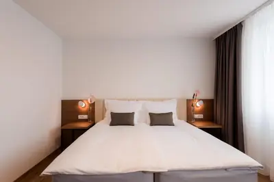 a bedroom with a large white bed with two pillows at Hotel Ajdovec in Sevnica