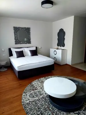 a bedroom with a white bed and a white table at Hotel Ajdovec in Sevnica