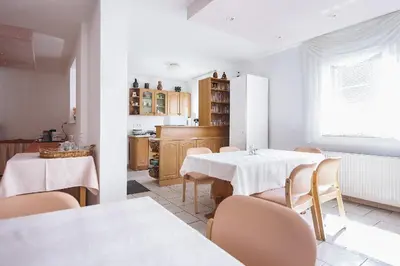 a dining room with two tables and chairs and a kitchen at Prenočišče Šinkec Nada in Moravske Toplice