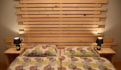a bedroom with two beds and a wooden headboard at Guest House Park Žibert in Ljubljana