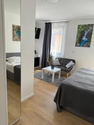a bedroom with a bed and a couch and a mirror at Gostisce Sovdat in Bovec