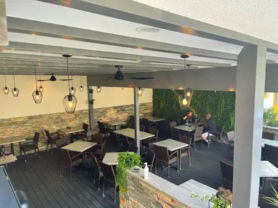 a restaurant with tables and chairs on a deck at Gostisce Sovdat in Bovec