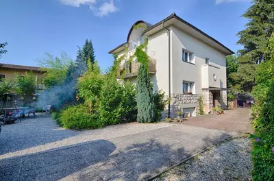 a house with a tree in front of it at Guesthouse GreenSLO in Ljubljana