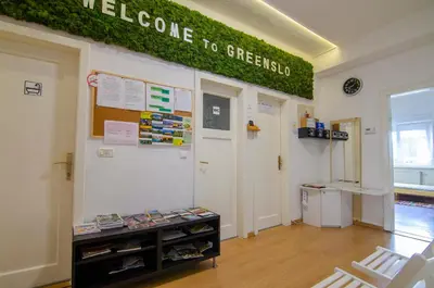 a classroom with a green sign on the wall at Guesthouse GreenSLO in Ljubljana