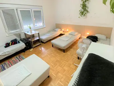 a living room with two beds and a couch at Guesthouse GreenSLO in Ljubljana