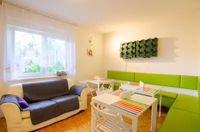 a living room with a couch and tables and a window at Guesthouse GreenSLO in Ljubljana